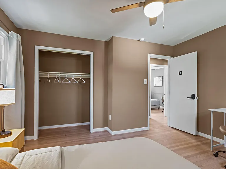 Room 4 - Large bedroom + bedside table + lamp + mini refrigerator + reach-in closet + extra storage + ceiling fan w/ light