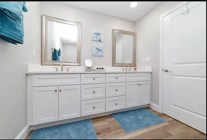 Primary upstairs ensuite bath with double sinks, a spacious walk-in shower, and elegant finishes.