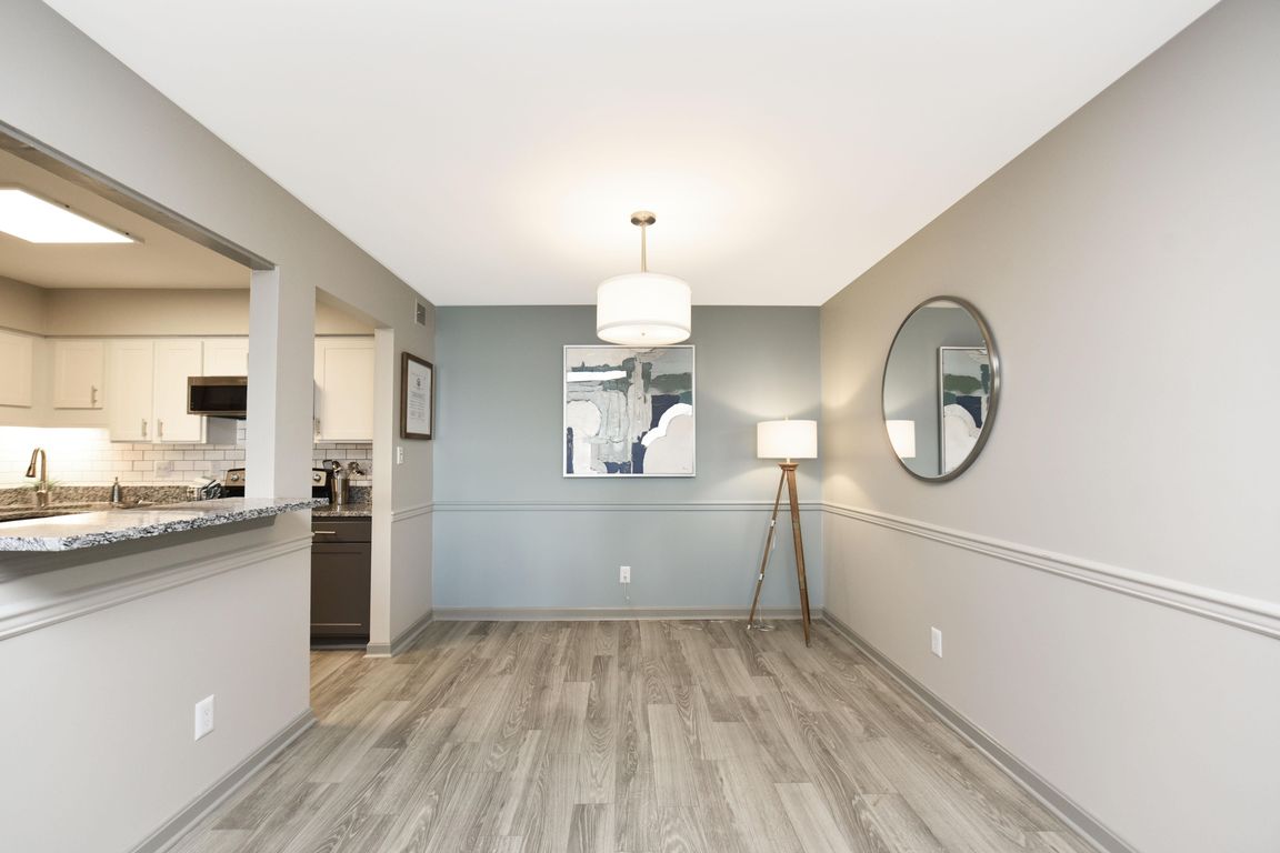 Dining area with hardwood-style flooring and overhead lighting
