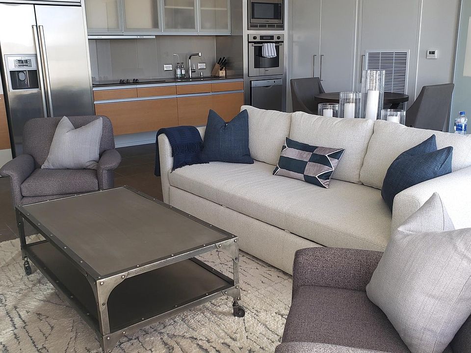 The living room features a stylish sofa that effortlessly transforms into a full-size, ultra-comfortable queen bed, perfect for accommodating guests.