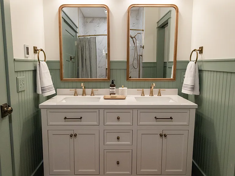 The full bathroom is located on the second floor between the two bedrooms and includes a double vanity, a shower/tub, and a toilet with a pocket door for privacy.