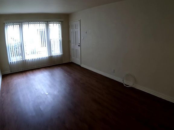 Large living room, wood laminate floors and large window for natural light.