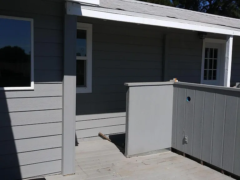 View from deck showing top of entry stairs. Window on the left opens to kitchen.