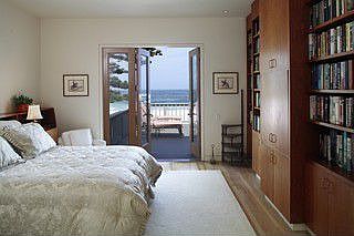 Master bedroom with built in bookshelves and direct access to the deck
