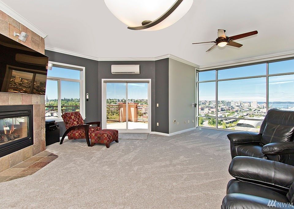 Huge picture windows and balcony slider overlooking the city and Puget Sound. Windows equipped with luxury Hunter Douglas electronic blinds. TVs stay!