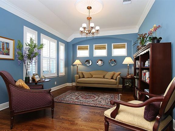 To the left of the entry is this living room that could be used as a study. Love the trio of small windows that allow extra light to spill into this space. Note the plantation shutters, the double crown molding, ceiling medallion and gorgeous oak flo