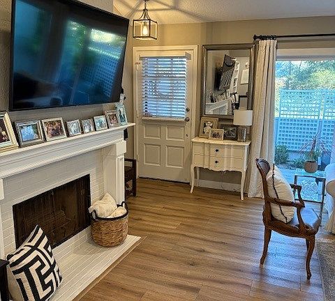 Family room with custom fireplace and luxury vinyl plank flooring. Mounted TV stays with the unit.
