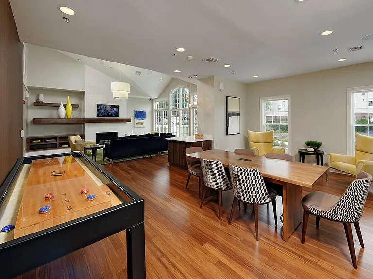 Resident lounge with common area seating, shuffleboard and flat screen television