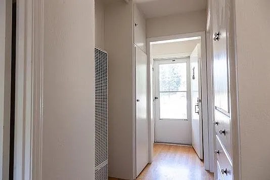 Middle hallway facing the front door. Storage and wall heater are visible.