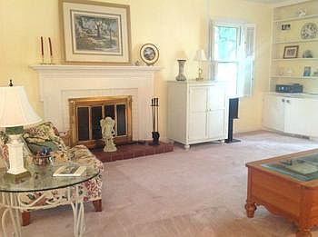Formal living room has wood burning fireplace
