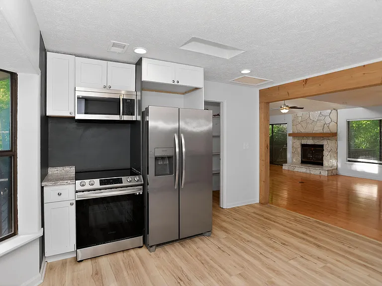 Compact kitchen with stainless steel appliances, ample cabinet storage, and an open pass-through to the main living area.