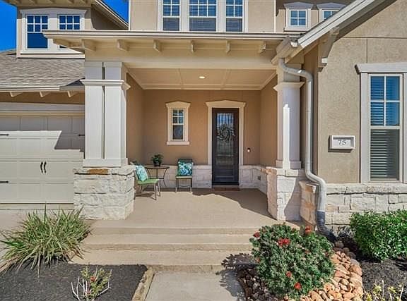 Mid-sized inviting front porch with stone surround and cool decking.