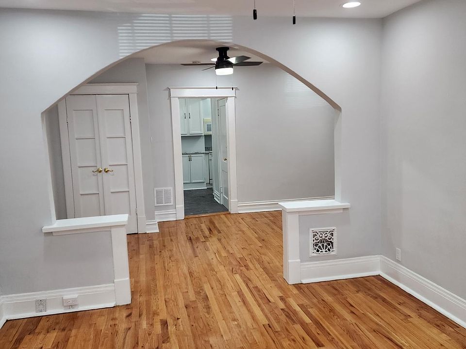 Looking from the front door into the front two rooms. Beautiful Hardwood Floors with connecting Archway