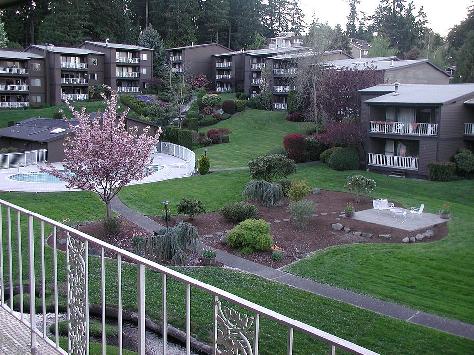 Deck overlooks the beautiful park like grounds with a creek trickling through.