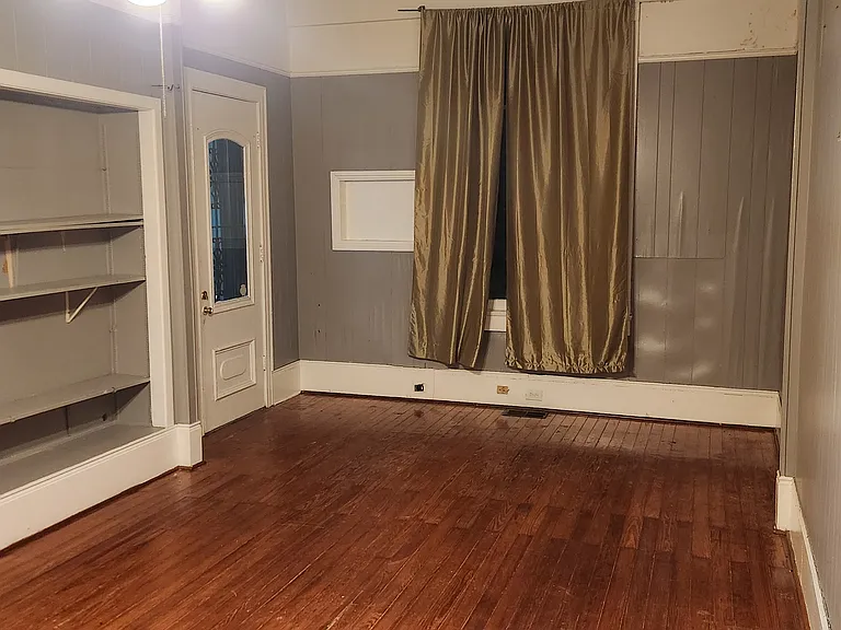 Living dining room from the kitchen door. Big window looking out onto back yard. The main entry door from the screened porch.
