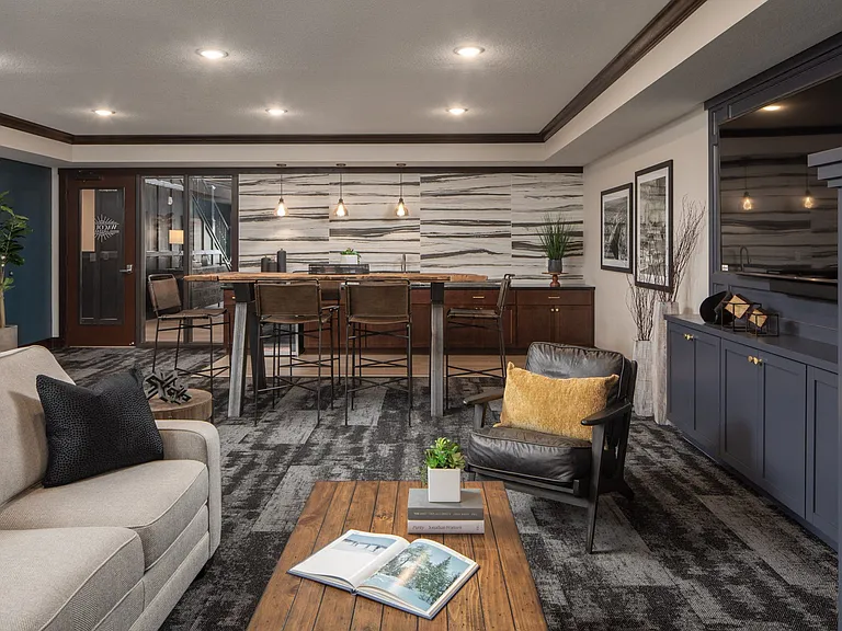 Lounge area with couch, tables, and chairs, with breakfast bar at The Whitley.