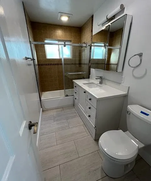 Bathroom #2 with new tile, toilet and mirrored medicine cabinet.