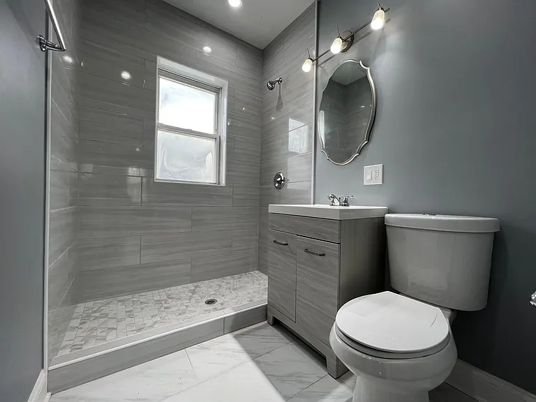 Newly renovated bathroom with linen closet. Note: glass shower door will be installed before tenant moves in.