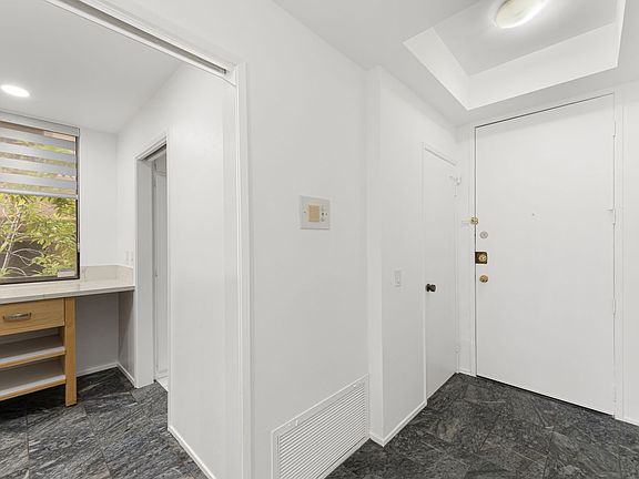 Entry way - interior view with view of powder room and glimpse into kitchen & entry to laundry room