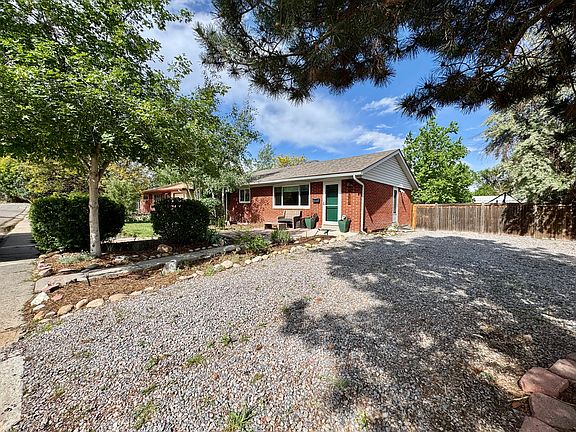 Front of the home with large gravel driveway.