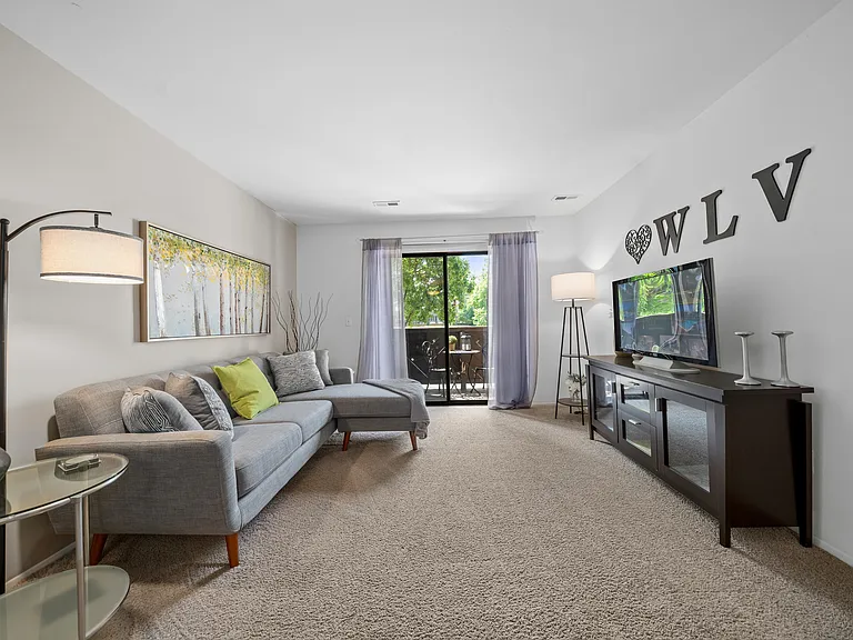 Cozy living room with natural light at Woodland Villa Apartments in Westland, MI.