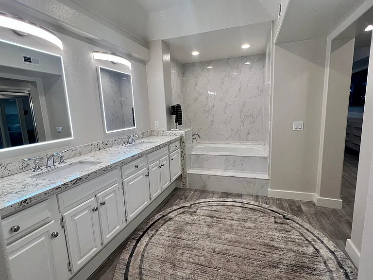 Primary bedroom bathroom with double vanity and large deep bathtub