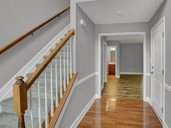 The living room is ahead and the garage entry is on the R