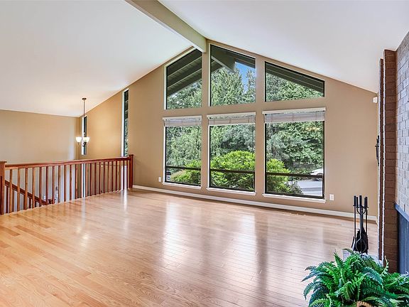 Wide staircase leads to an open floorplan with vaulted ceilings, large windows and smart design.>