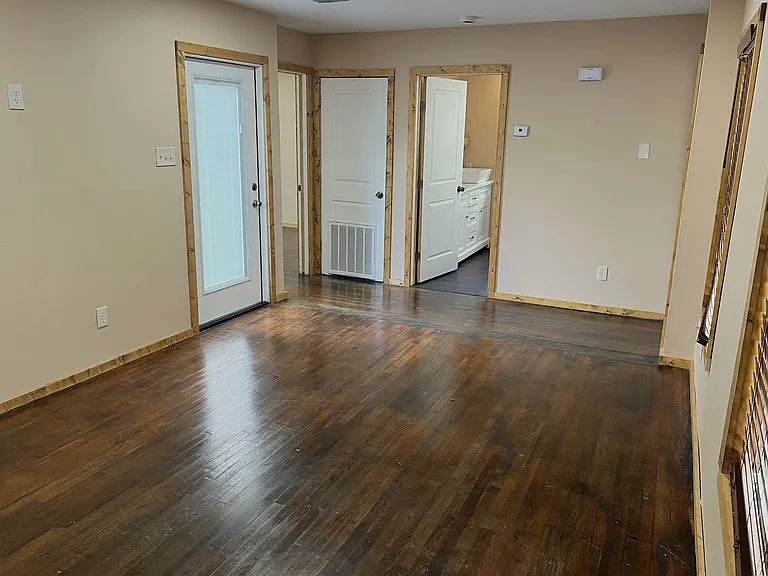 The living room continues, leading to the bathroom and bedrooms