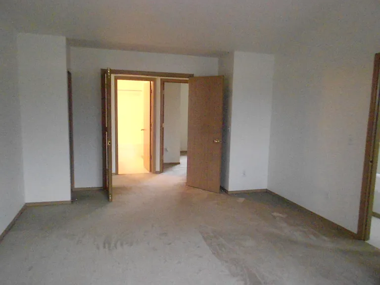 View from inside of master bedroom with double doors. Extra closet near door.