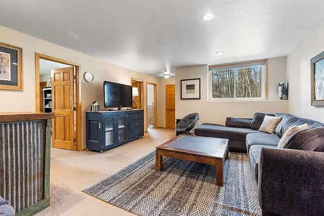 Lower level family room with TV, plus two additional bedrooms and bathroom.