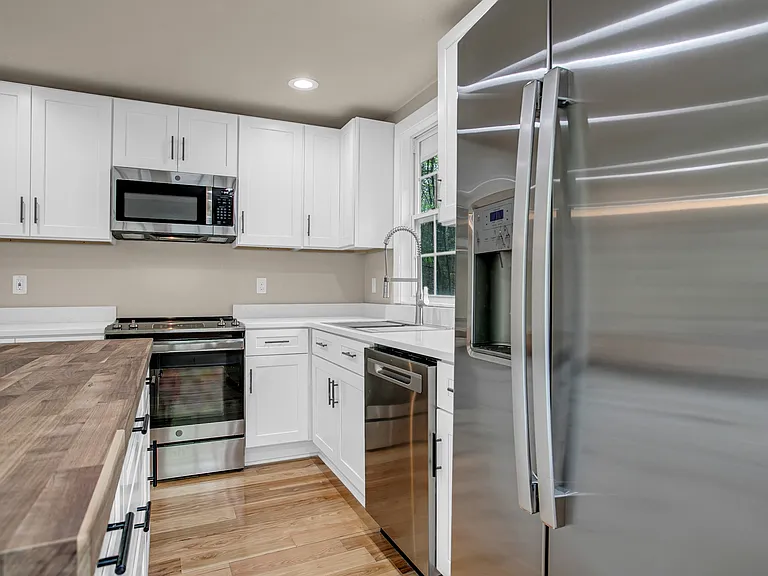Stainless steel appliances. Maple Butcher block counter top for Island and quartz countertops.