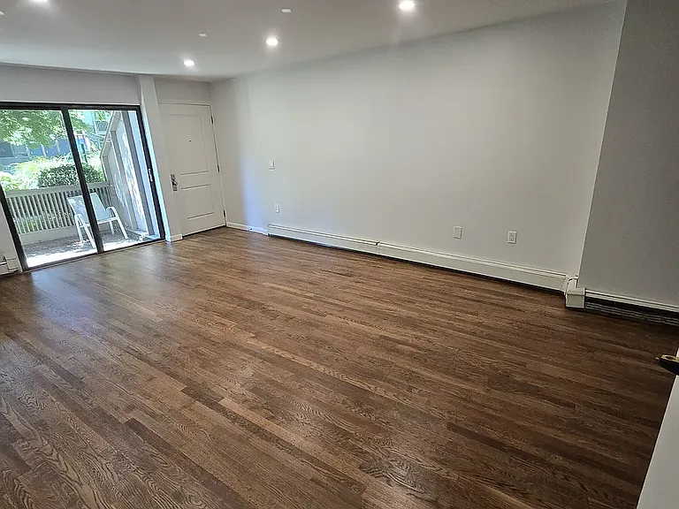 Livingroom leading to patio overlooking beautiful landscaped grounds and pond