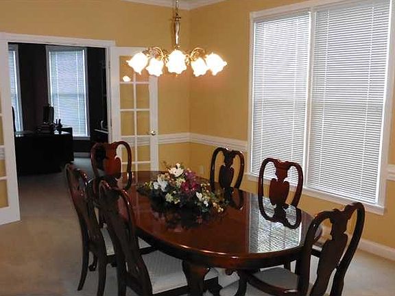 Dining Room. The Dining Room is generously sized, allowing for a large table and other serving pieces  It features crown molding, wainscoting, and glass doors leading to the office