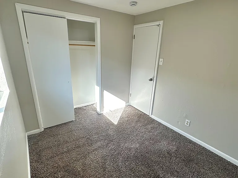 Bright and cozy room with plush carpeting and ample closet space, perfect for a peaceful retreat.