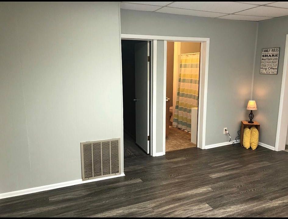 Living room. door on right is the bathroom with tub/shower combo. Door on right is utility room for extra storage.