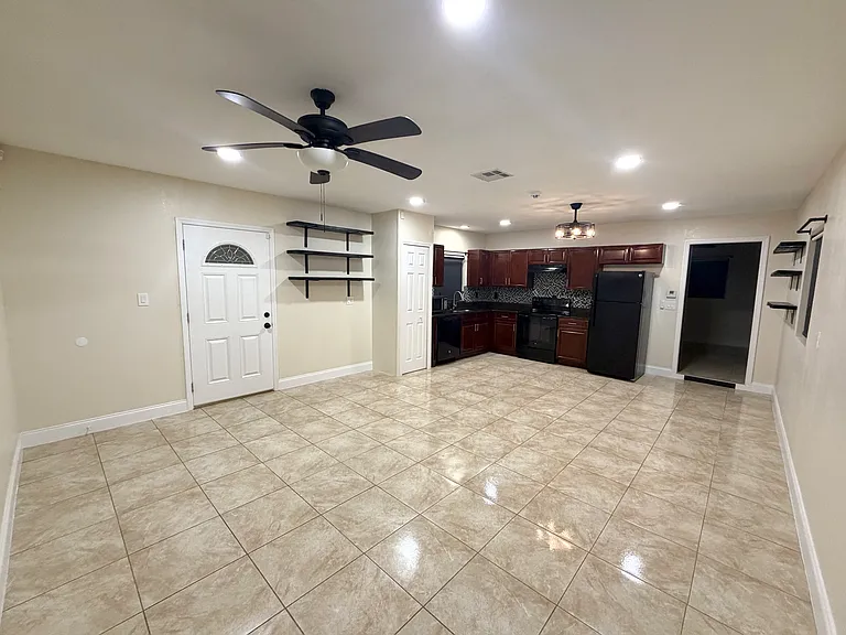The open_concept living room offers bright windows with blackout shades and warm recessed lighting throughout the space. (Angle 2)