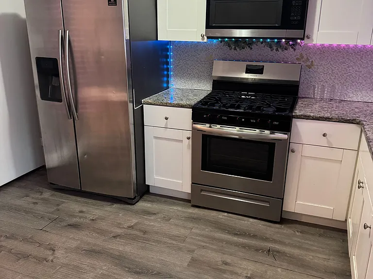 Updated kitchen with shaker cabinets, granite-look counters, mosaic backsplash, and stainless steel appliances for everyday c