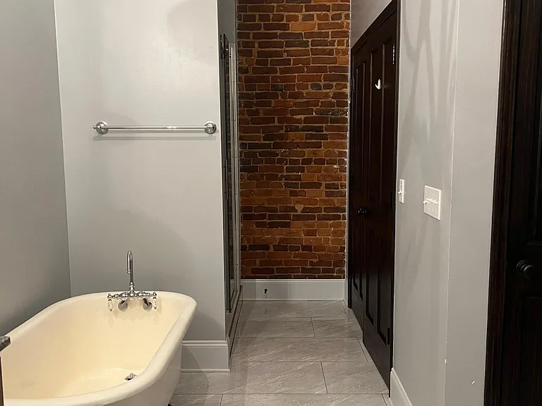 Bathroom with claw foot bathtub, shower, closet and linen closet.