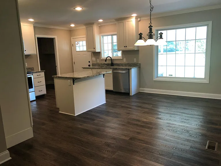 Beautiful new kitchen has cream cabinets and granite counter. Dining area has picture window that looks over back yard.