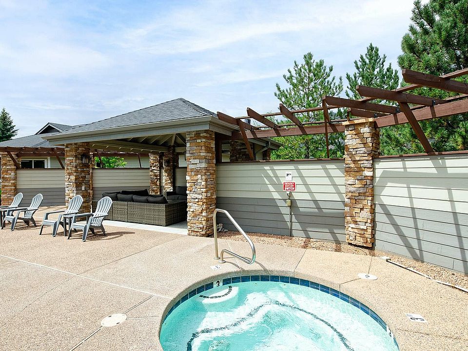 Relax in this serene outdoor lounge featuring a stylish pergola and soothing hot tub.