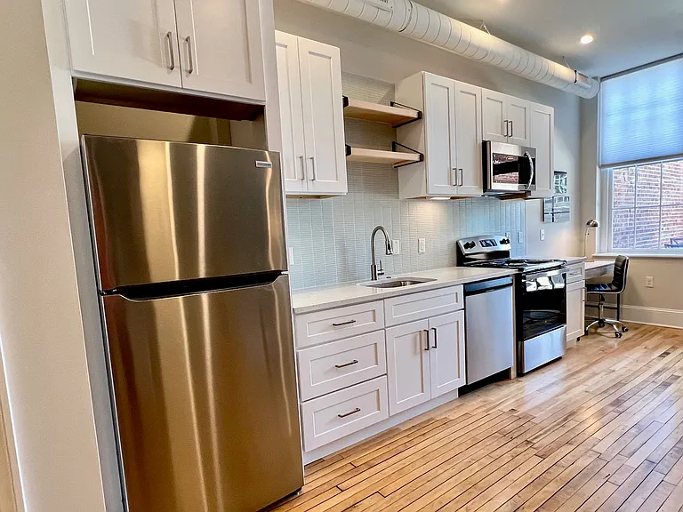 Kitchen wall. Plenty of cabinetry, good LED lighting, maple open shelf accent above sink, brand new appliances. The cabinets throughout are wood, no MDF, no laminate surfaces. All feature soft-close drawers.