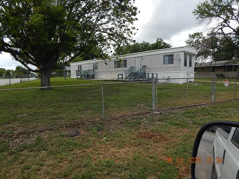 View of home from corner at Montgomery & Michelle Way -showing large shade trees and both south side entrances to home