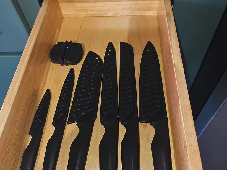 Kitchen stocked with knives of different sizes for easy prep.