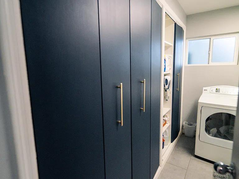 Laundry room features a high-efficiency washer and dryer and storage for extra pantry and cleaning supplies (2 cupboards are reserved for owner storage)