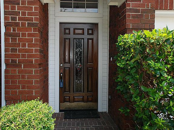 Beautiful hardwood front door with leaded glass insert & transom welcomes you