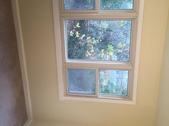 the rear bedroom looks out over mature trees and landscaping