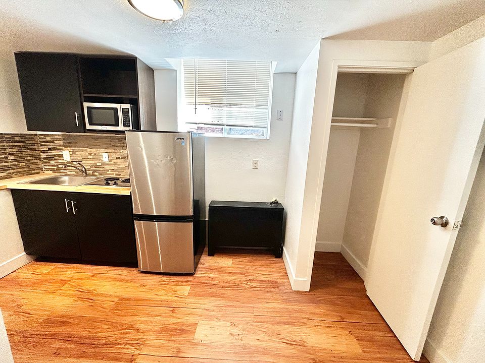 Contemporary kitchen with sleek stainless steel appliances, modern cabinetry, and elegant wood flooring, perfect for stylish urban living.