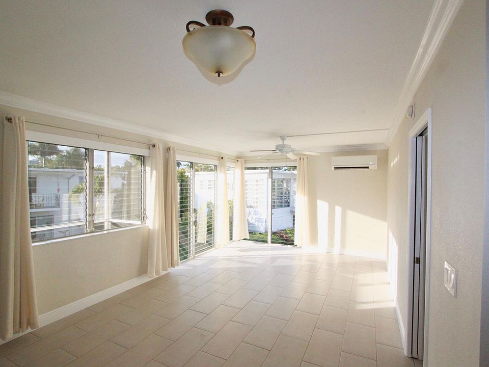 Living room with Floor to ceiling hurricane impact windows and split a/c.