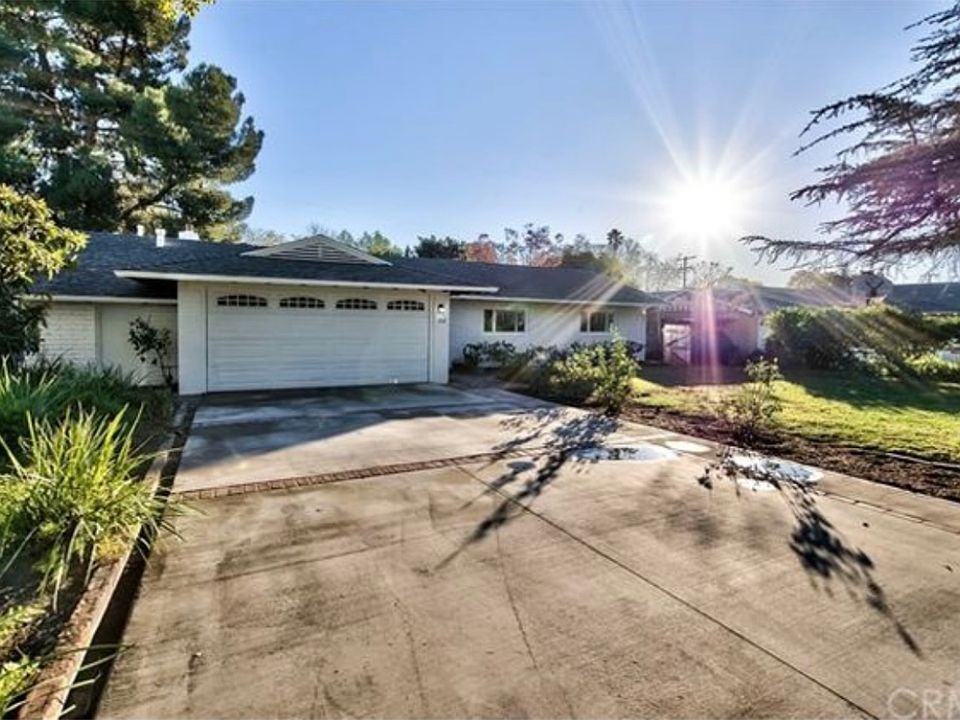 Charming curb appeal with classic brick construction, mature landscaping, and a wide driveway set on a spacious 10,000 square-foot lot with a lush front yard and tree line street.